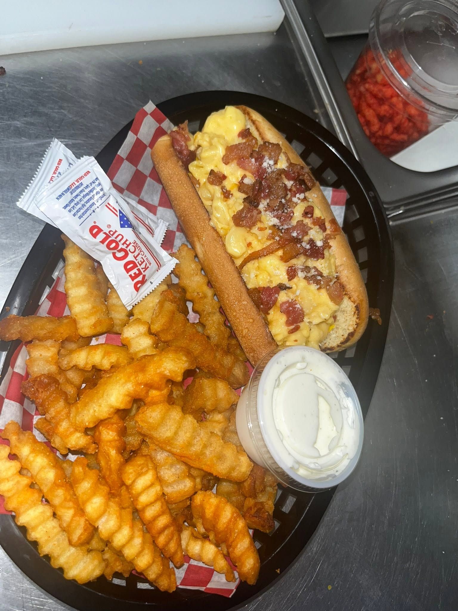 Bacon mac and cheese dogo served with crinkle-cut fries and dipping sauces