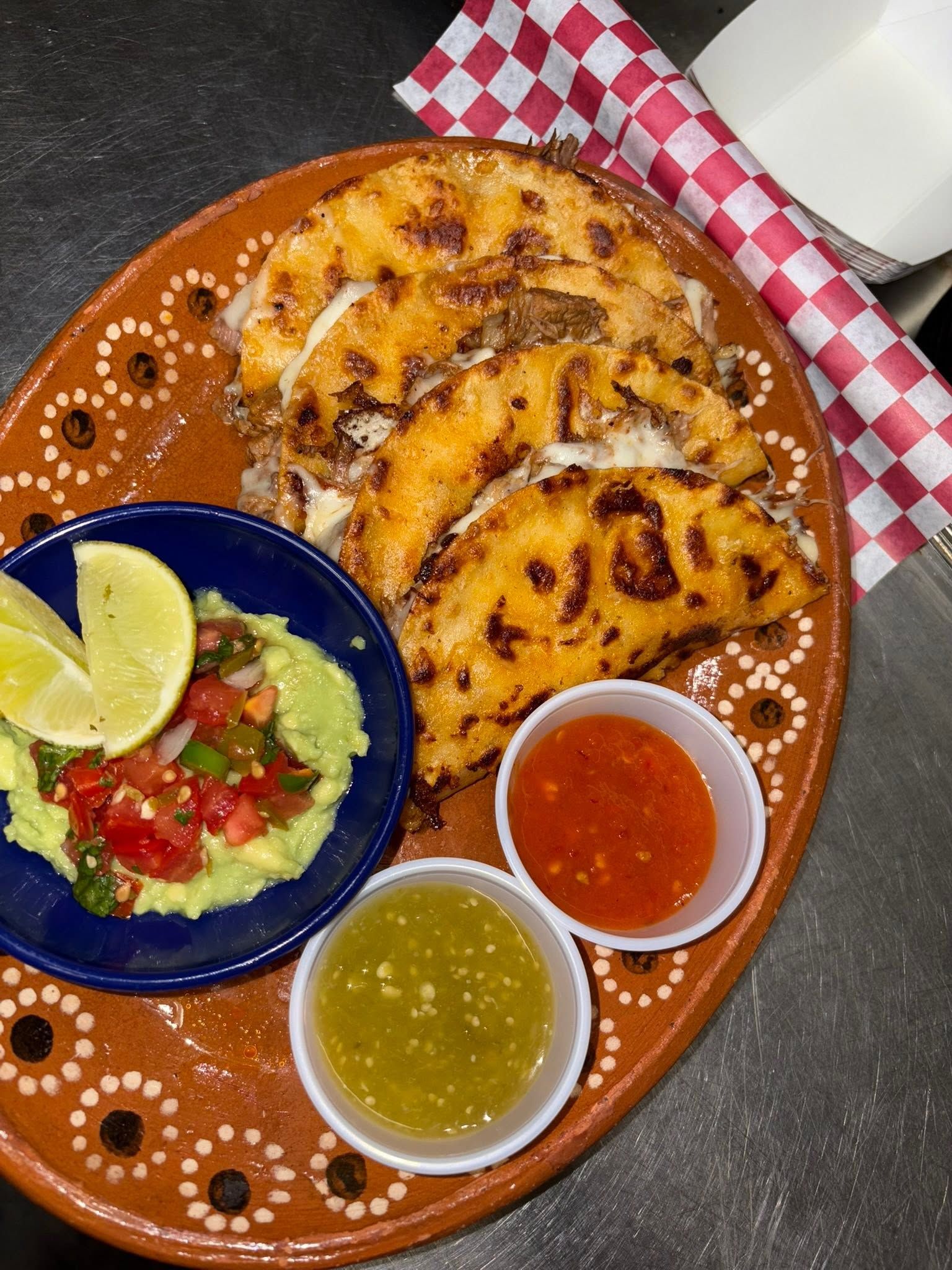 Crispy cheese-and-beef folded tortillas with guacamole, lime, and red and green salsa