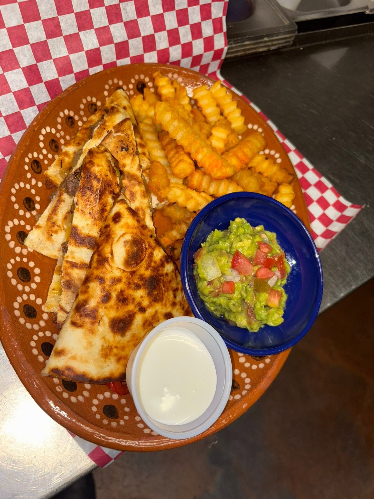 Quesadilla wedges with crinkle-cut fries, guacamole, and sour cream
