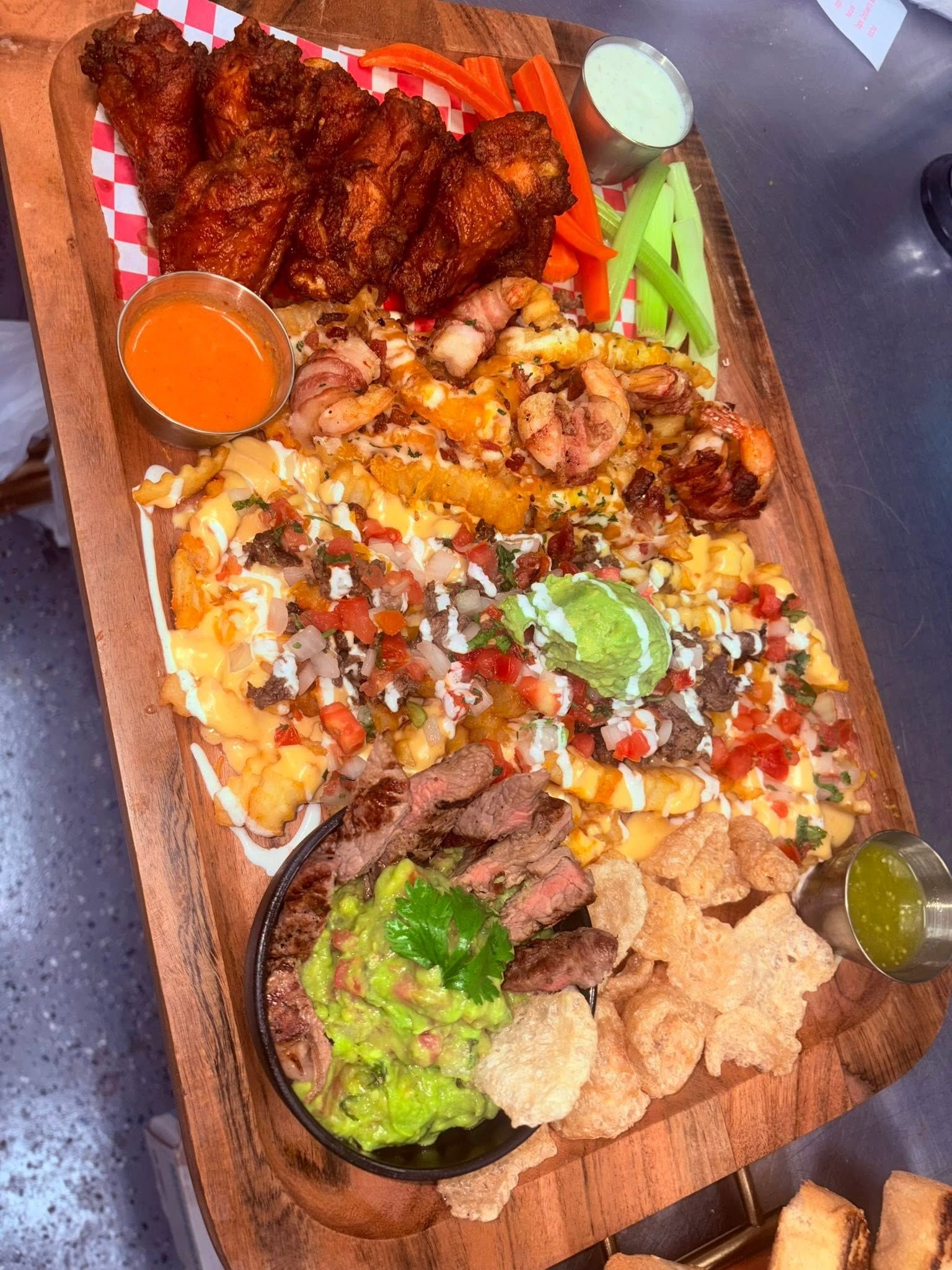 Loaded sampler board with wings, cheese fries, shrimp, and chicharrones