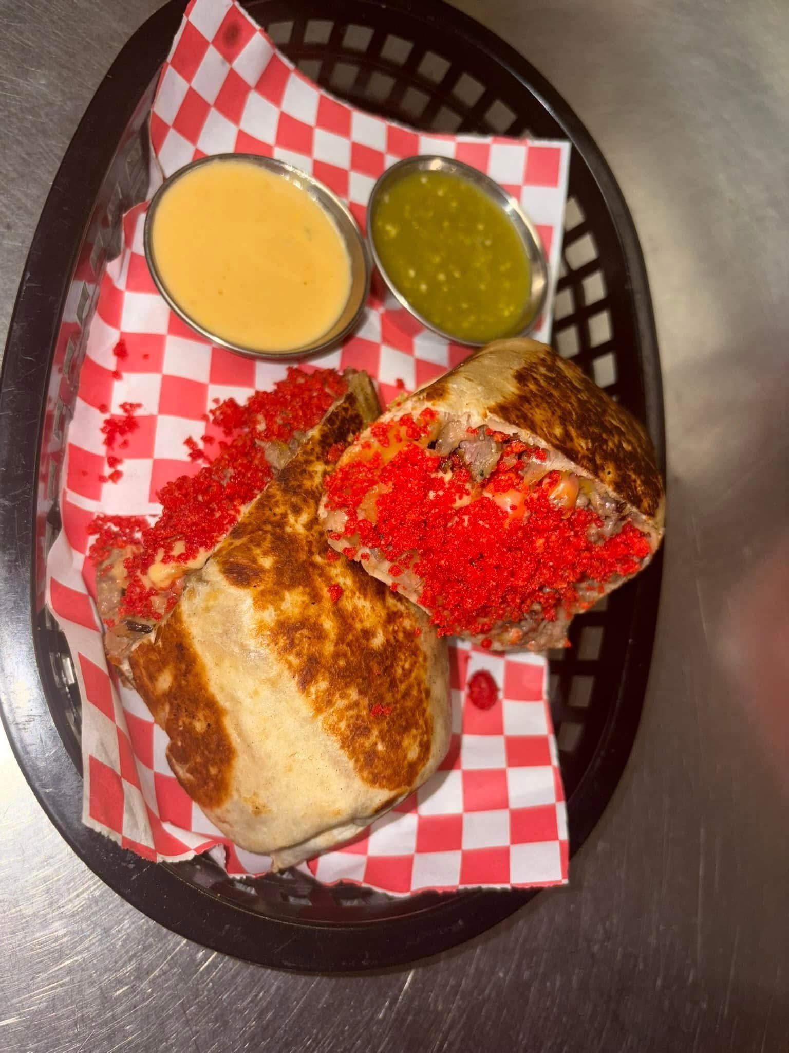A torta crusted in red chile with green and orange salsas